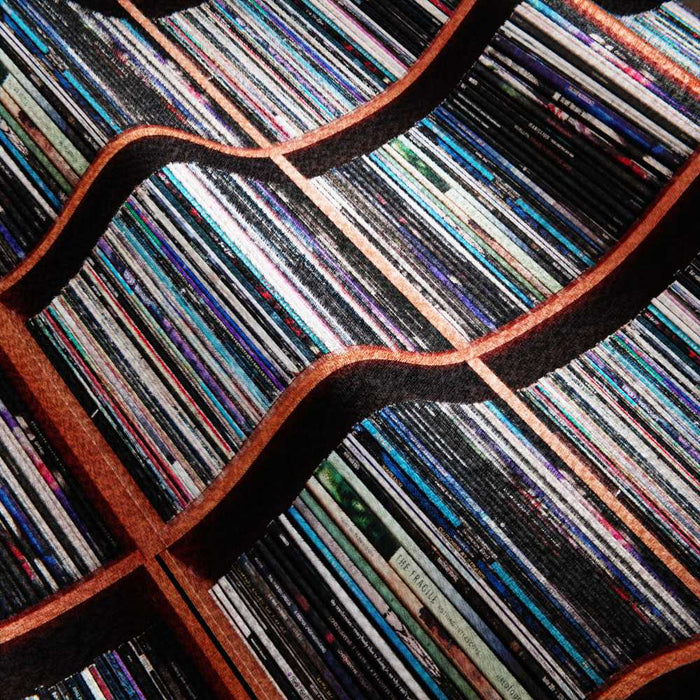 A closeup of a blanket, the blanket having an image of a vinyl record collection on it