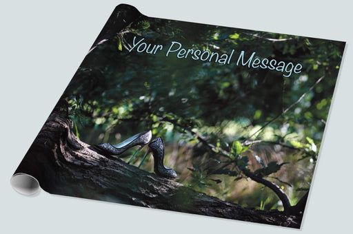 A roll of wrapping paper showing a pair of shoes resting on a branch of a tree, the tree being in a forrest and there are other trees in the background, along with a personal message