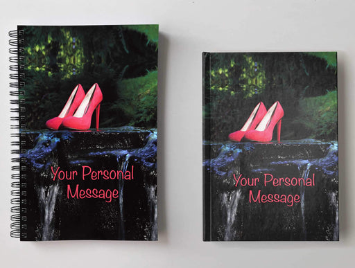 Two notebooks, side by side, both having an image of pink high heeled shoes on a rock midway across a flowing river, along with a personal message on the cover