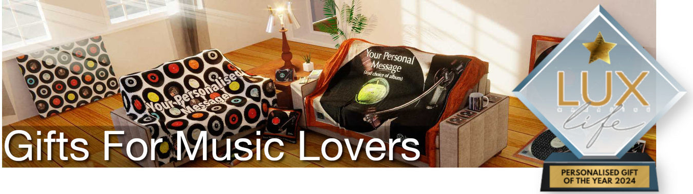 A view of a living room containing multiple music themed soft furnishings including two music themed blankets thrown over two couched and some music themed vinyl record canvas prints laid up against the wall