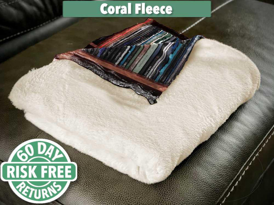 A folded fleece blanket, mostly showing the white fleece underside, with a folded corner revealing part of an image of vinyl records on a shelf