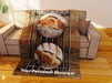 a fleece blanket flat on a couch, the blanket having an image of two sourdough loaved of bread sat on a metal wire tray, along with a printed personal message