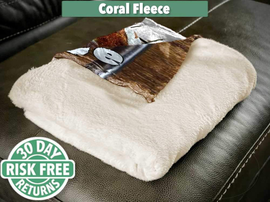 A folded coral fleece blanket sat on a couch