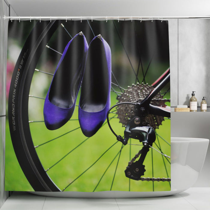 A shower curtain in a bathroom, the shower curtain having an image of a pair of purple high heel shoes hung on the spokes of a bicycle