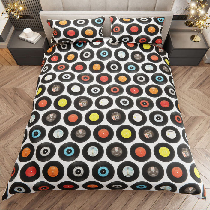 a duvet cover and pillows with 7 inch vinyl records printed on it, on a bed within a wider bedroom setting and seen from directly above the bed