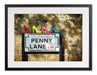 A framed print with a black frame, the print showing four coloured high heel shoes sat on top of the penny lane road sign in liverpool