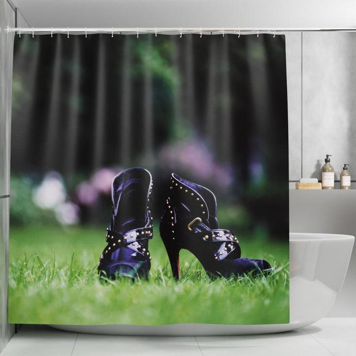 A shower curtain in a bathroom, the curtain having an image of a pair of purple high heel ankle boots sat on the grass of a lawn in a garden