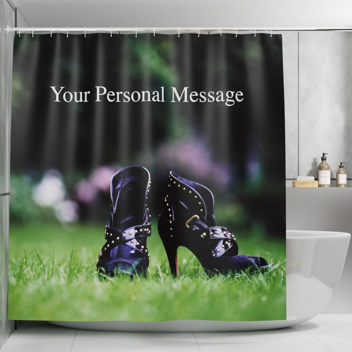 A shower curtain in a bathroom, the curtain having an image of a pair of purple high heel ankle boots sat on the grass of a lawn in a garden, along with  a printed personal message on the curtain