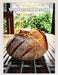 A jigsaw showing an image of a large sourdough loaf on  a table with a garden visible behind through the window