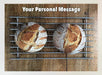 A jigsaw with an image of two sourdough loaves seen from directly overhead, the loaves sitting on a metal tray along with a printed personal message