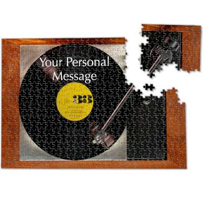 A jigsaw of a record player, the record player having a vinyl record on it with a yellow label, the jigsaw is slightly broken with a corner broken away from the main jigsaw