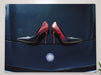 A canvas print of a pair of blue high heel shoes sitting on the bonet of a high powered card