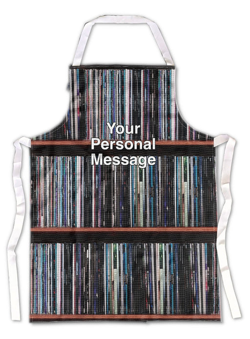 an apron laid flat on a white tiled floor, the apron having images of lots of vinyl records in a record case, with a personalised message printed