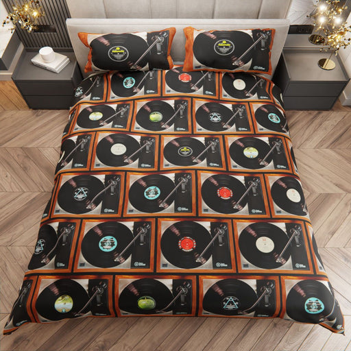 a bed with a duvet cover showing a mosaic image of record players, with vinyl records playing, and seen from a point above the bed
