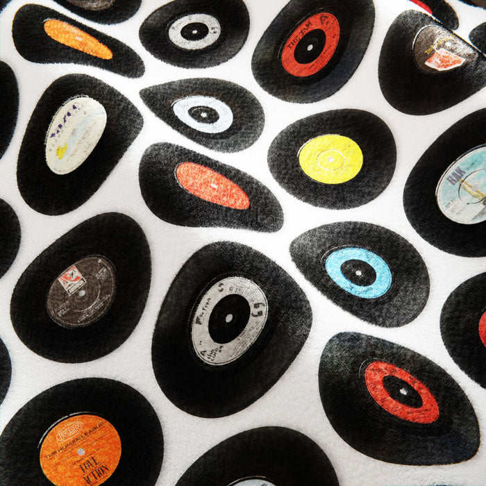 a closeup of a fleece blanket, the blanket having images of vinyl records on it