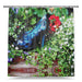 A shower curtain showing an image of a pair of blue high heel shoes in a flower bed, with a white background
