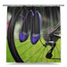 A shower curtain showing an image of a pair of high heel shoes hooked onto the spokes of a rear wheel of a road bike, with a white background
