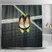 A shower curtain in a bathroom, the curtain having an image of a pair of yellow and black high heel shoes hung over a tennis net on a tennis court