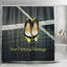 A shower curtain in a bathroom, the curtain having an image of a pair of yellow and black high heel shoes hung over a tennis net on a tennis court, along with a printed personal message