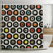 A shower curtain hung in a bathroom, the shower curtain having a montage of vinyl records on it along