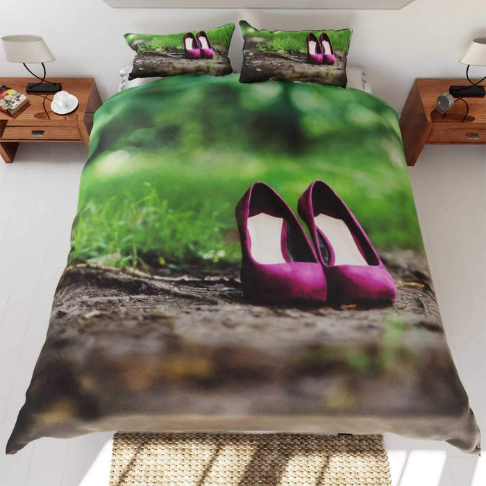 A duvet cover showing a pair of purple high heel shoes on a muddy path in a forest, the duvet is on a bed an seen from top 