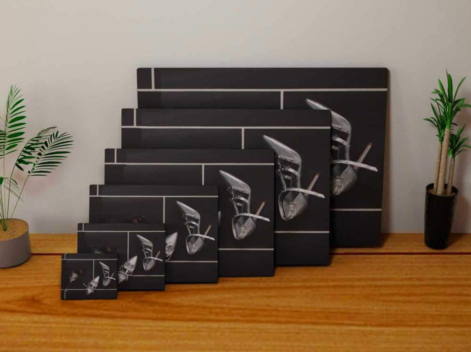Multiple sized canvas prints, each print of an image of a spilt cocktail drink with a fallen cocktail glass on a black floor, with a pair of silver high heel stilettos lying next to the spilt drink