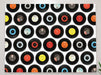A canvas print of a mosaic of 7 inch vinyl records hanging on a wall in a living room 