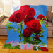A fleece blanked draped over a couch, the blanket having an image of red roses on it along with a personalised text message