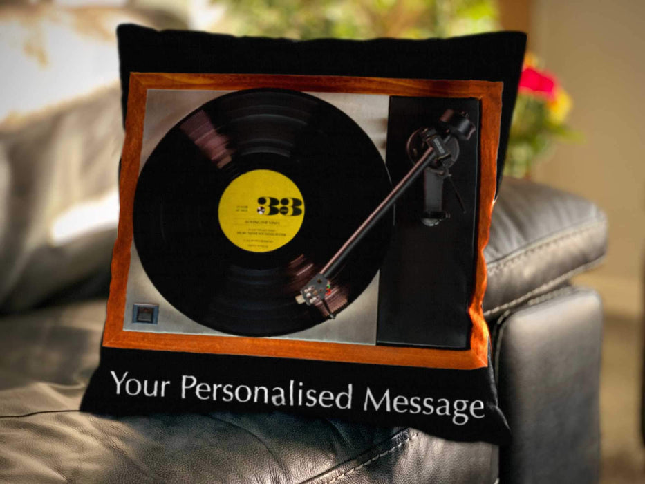 A cushion with image of a vinyl record and record player on it, with a yellow record label