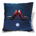 An image of a cushion, the cushion having an image of a pair of red and blue high heel shoes sat upon the bonet of a car