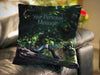 An image of a cushion sat on a couch, the cushion cover shows a pair of shoes sat on a tree branch within a forest woodland along with a personal message