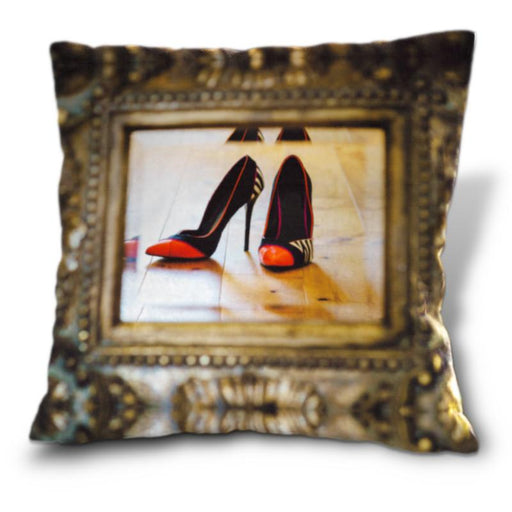 An image of a cushion, the cushion cover showing a mirror with a pair of orage and black high heel shoes reflected in it