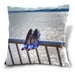 An image of a cushion, the cushion showing an image of a pair of blue shows hung on the railings adjacent to ocean with the water sparkling behind