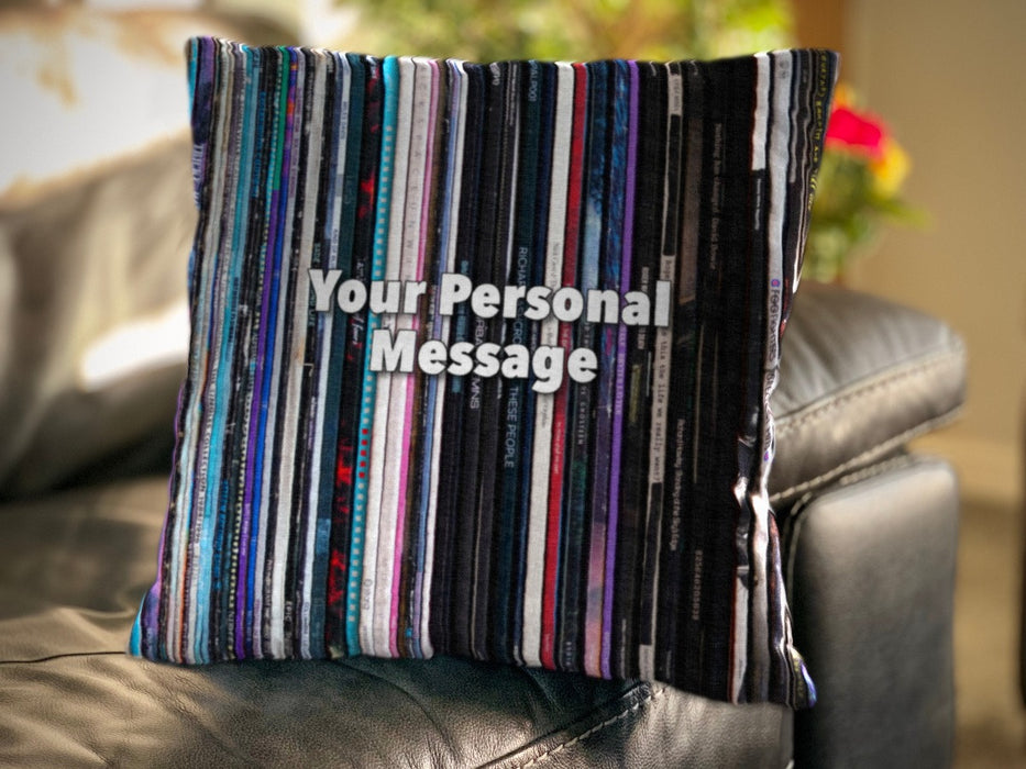 a cushion on a sofa, the cushion having an image of multiple vinyl records stacked along a shelf along with a personal message