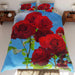 A duvet on a bed, the duvet having a pattern of red roses with blue sky in the background