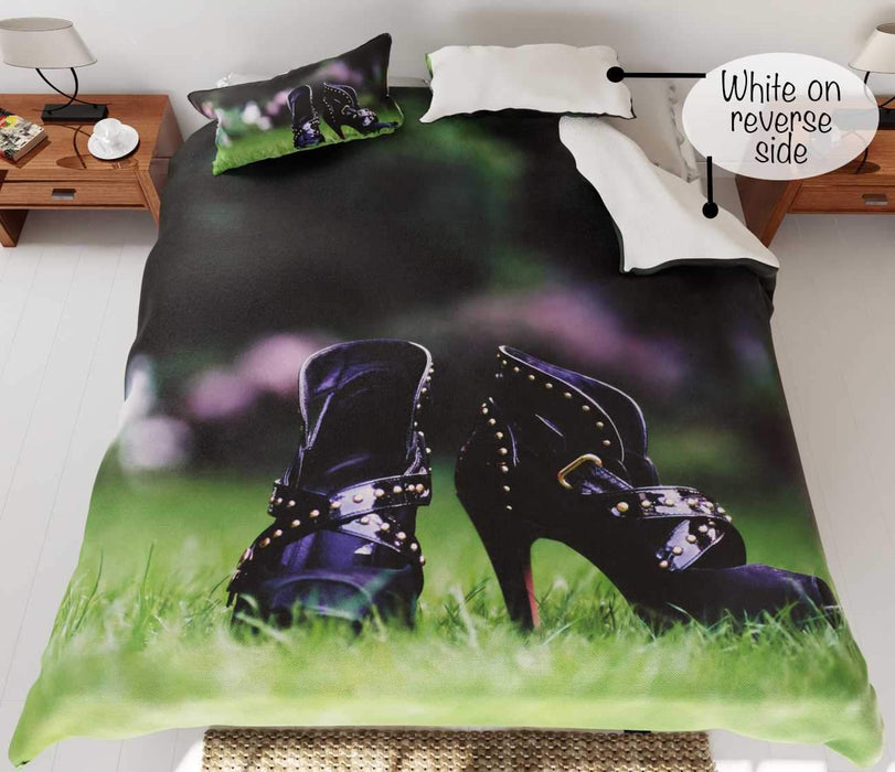 A duvet cover on a bed, the duvet featuring a pair of purple high heel ankle boots stood on a garden, part of duvet is folded back to reveal a white underside