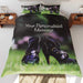 A duvet cover on a bed, the duvet featuring a pair of purple high heel ankle boots stood on a garden, along with a personal message on the duvet