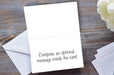 the inside of a greeting card, the card opened, showing a message, the card is on a dark grey table with an envelope in partial view