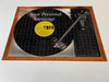 picture of a jigsaw of a record player with a vinyl record on it, the record having a yellow label, and also containing a personal message, the jigsaw is seen from angled position
