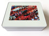 A white tin box, and there is an image on the box of multiple rows of ladies high heel shoes