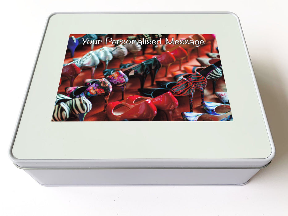 A white tin box, and there is an image on the box of multiple rows of ladies high heel shoes