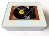 A white box, on the lid of the box is an image of a record player with a vinyl record playing on the record player