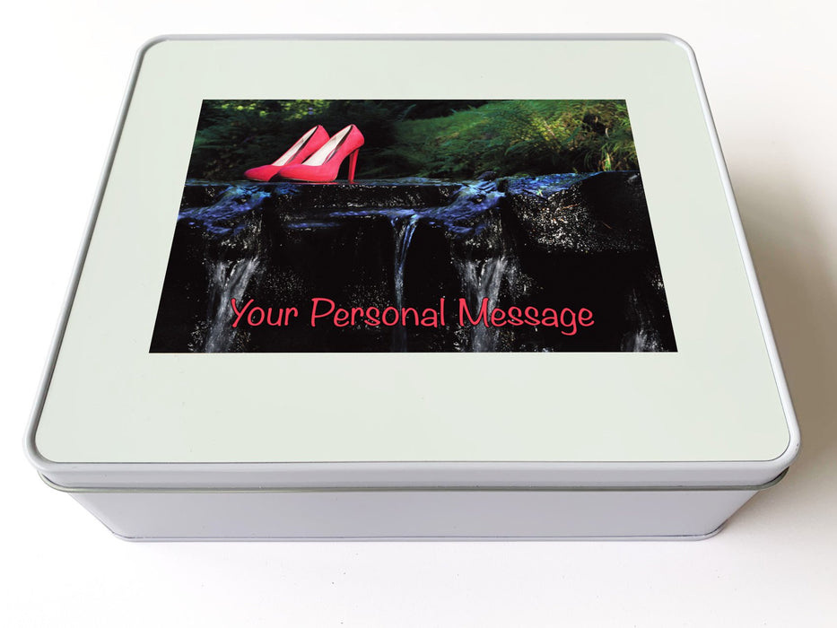 A white tin box, the box lid having an image of a pair of pink shoes sitting on a rock within a flowing river a personal message