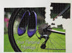 A jigsaw seen from the top, the jigsaw having an image of a pair of purple high heel shoes hung on the rear wheel of a road bike, along with a personal message, the jigsaw is slightly broken up