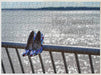 A jigsaw with an image of a ocean with a pair of high heel shoes hanging on the railings in the foreground