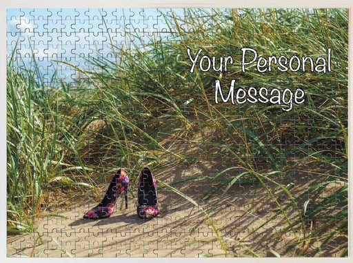 A jigsaw seen from the top, the jigsaw having an image of a pair of high heel shoes sat upon a beach near side a sand dune, along with a personal message
