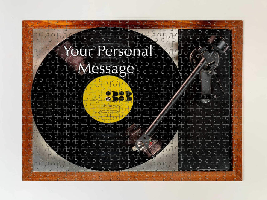 picture of a jigsaw of a record player with a vinyl record on it, the record having a yellow label, and also containing a personal message, the jigsaw is seen from above