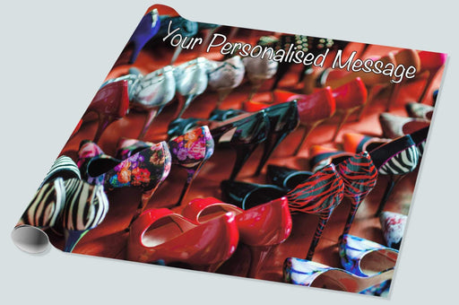 A roll of wrapping paper showing large number of high heeled shoes all lined up next to each other along with a personalised message