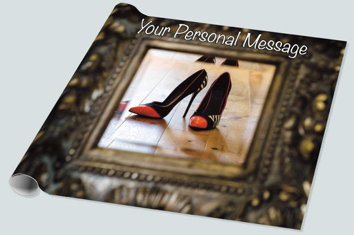 A roll of wrapping paper showing a mirror, the mirror surrounded by a brass mount, an in the mirror is a reflection of a pair of orange high heel shoes along with a personal message