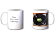 Two ceramic tea and coffee mugs, one showing a record player with a vinyl record playing, the other mug showing a personal message